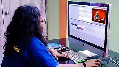 Student editing video at MDFA using Adobe Premiere Pro